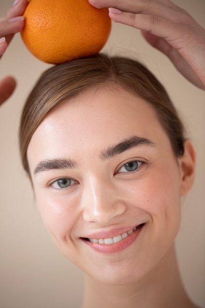 Portret Pięknej Kobiety Z Czystą Skórą Trzymającą Pomarańczowe Owoce