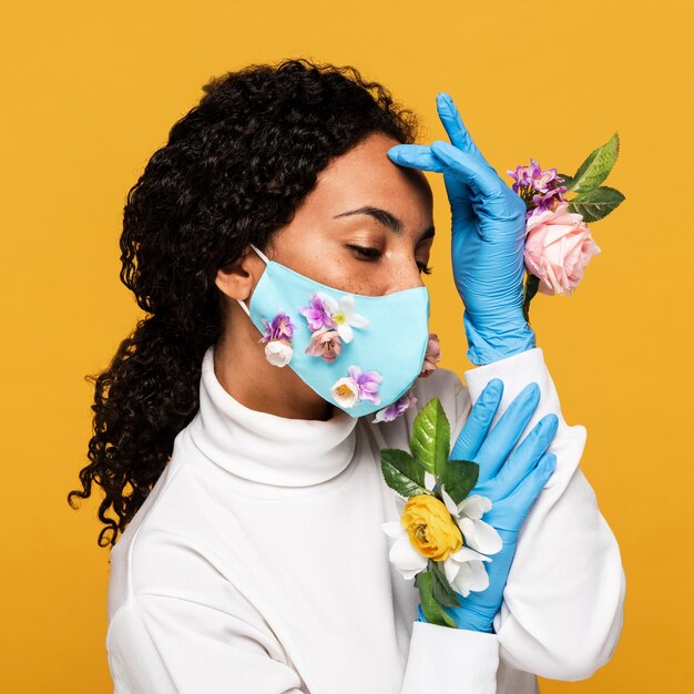 Portret pięknej kobiety z kwiatowymi rękawiczkami i maską