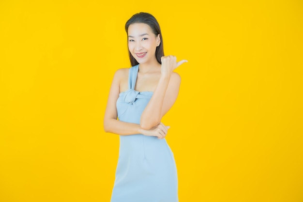 Portret pięknej młodej azjatyckiej kobiety uśmiech na żółto