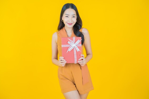 Portret pięknej młodej azjatyckiej kobiety uśmiech z czerwonym pudełkiem na prezent