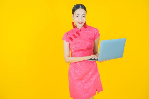 Portret pięknej młodej azjatyckiej kobiety uśmiech z laptopem na na białym tle