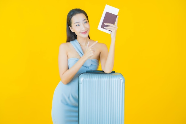 Portret pięknej młodej azjatyckiej kobiety z torbą bagażową i paszportem gotowym do podróży