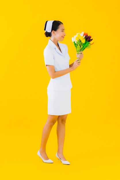 Portret pięknej młodej azjatykciej kobiety tajlandzka pielęgniarka z kwiatem