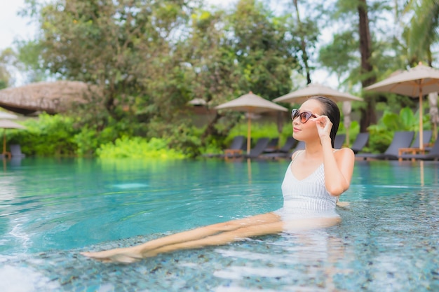 Portret pięknej młodej kobiety azjatyckie relaks przy odkrytym basenie w hotelowym kurorcie blisko morza