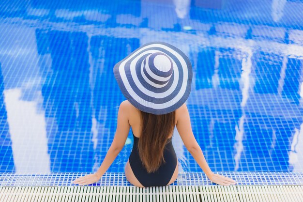 Portret pięknej młodej kobiety azjatyckie relaks przy odkrytym basenie w hotelowym kurorcie