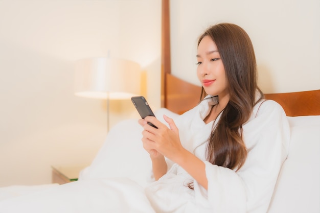 Portret Pięknej Młodej Kobiety Azjatyckie Za Pomocą Inteligentnego Telefonu Komórkowego Na łóżku We Wnętrzu Sypialni