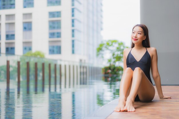 Portret pięknej młodej kobiety azjatyckie zrelaksować się uśmiech wokół odkrytego basenu w hotelowym kurorcie
