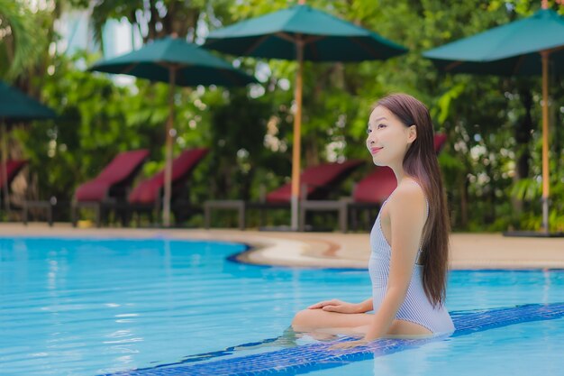Portret pięknej młodej kobiety azjatyckiej cieszyć się relaksujący uśmiech wypoczynek wokół odkrytego basenu w hotelu