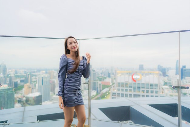 Portret pięknej młodej kobiety azjatyckiej szczęśliwy uśmiech na dachu restauracji wokół widoku miasta