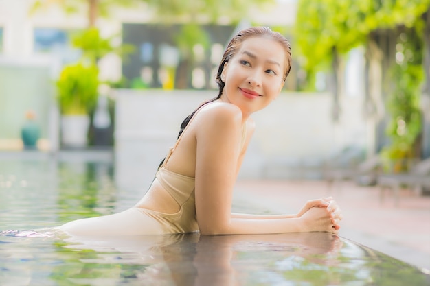 Portret pięknej młodej kobiety azjatyckiej zrelaksować się uśmiech wokół odkrytego basenu w ośrodku hotelowym w podróży wakacyjnej