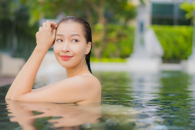 Portret pięknej młodej kobiety azjatyckiej zrelaksować się uśmiech wokół odkrytego basenu w ośrodku hotelowym w podróży wakacyjnej