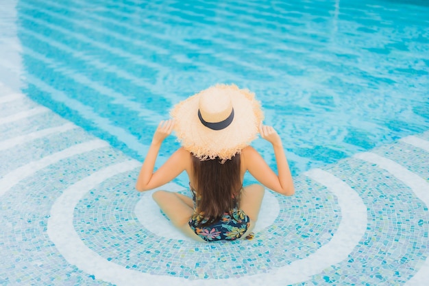 Portret pięknej młodej kobiety Azji relaksuje na basenie w hotelowym kurorcie