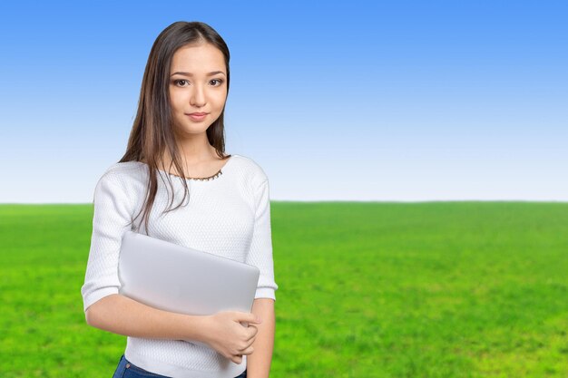 Portret pięknej młodej kobiety trzymającej laptopa na białym tle