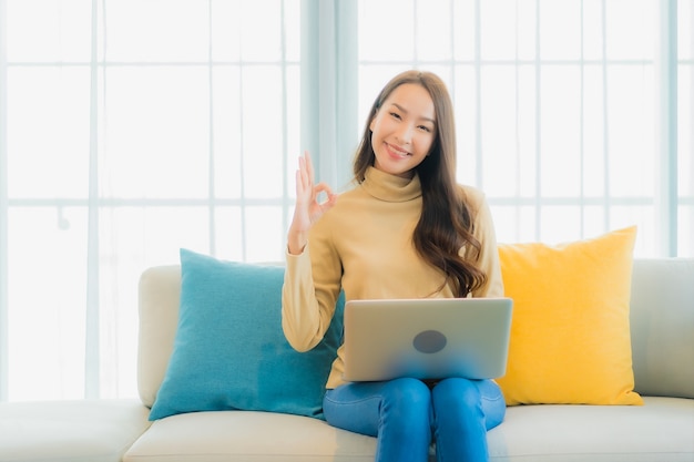 Portret Pięknej Młodej Kobiety Za Pomocą Laptopa Na Kanapie W Salonie