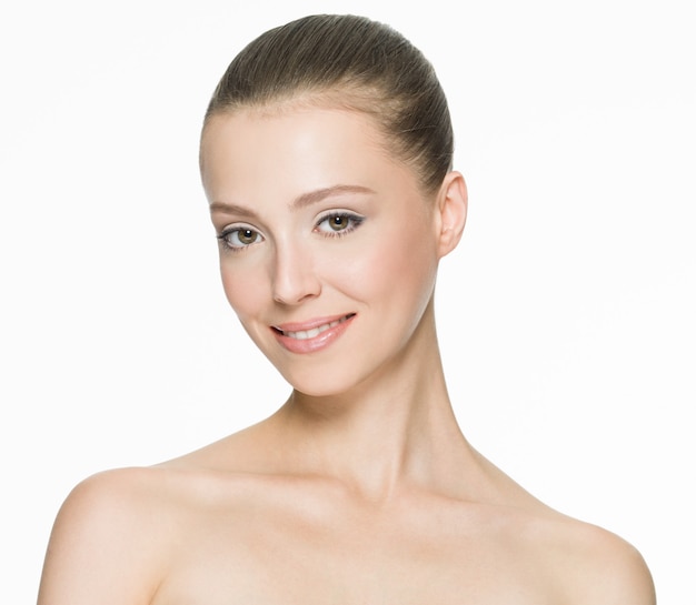 Bezpłatne zdjęcie portret pięknej uśmiechniętej kobiety z czystą skórą na białym tle