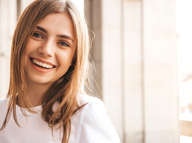 Portret piękny uśmiechnięty blondynu model ubierał w lato modnisiu odziewa.