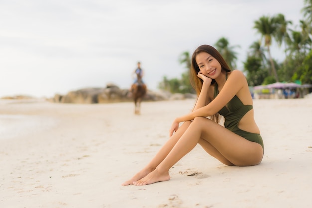 Portret pięknych azjatykcich kobiet szczęśliwy uśmiech relaksuje na tropikalnym plażowym dennym oceanie