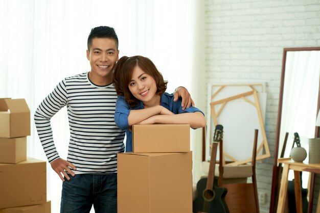 Portret pozuje przy pakunkiem boksuje szczęśliwa para przed przeniesieniem nowy mieszkanie