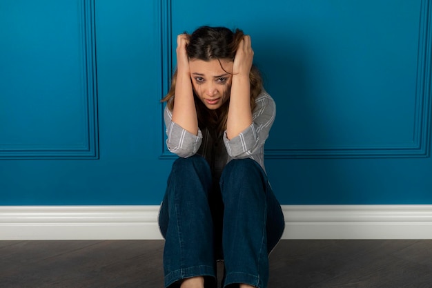 Portret Przygnębionej Dziewczyny Siedzącej Na Podłodze I Płaczącej. Zdjęcie Wysokiej Jakości