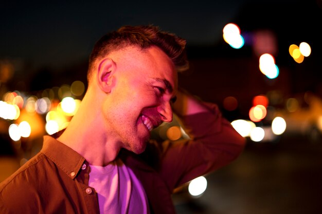 Portret przystojnego mężczyzny w nocy w światłach miasta