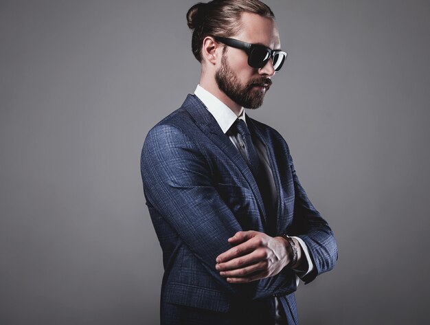 portret przystojny biznesmen modelka ubrana w elegancki niebieski garnitur z okularami przeciwsłonecznymi
