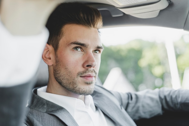 Portret przystojny młody biznesmen w samochodzie