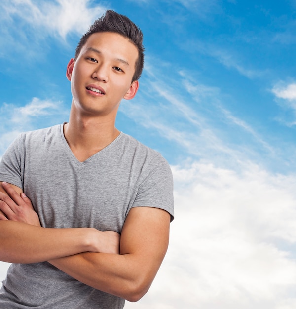 Portret przystojny młody mężczyzna azjatyckich z niebem w tle