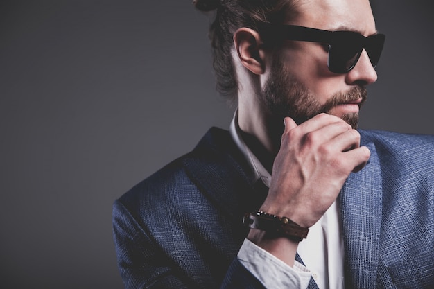 portret przystojny moda model hipster stylowy biznesmen biznesmen ubrany w elegancki niebieski garnitur na szaro