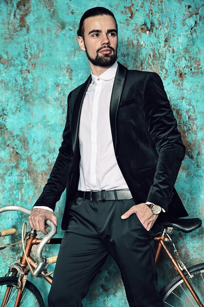 portret przystojny moda stylowy hipster biznesmen model ubrany w elegancki czarny garnitur.