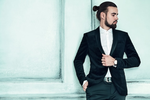 portret przystojny moda stylowy hipster biznesmen model ubrany w elegancki czarny garnitur.