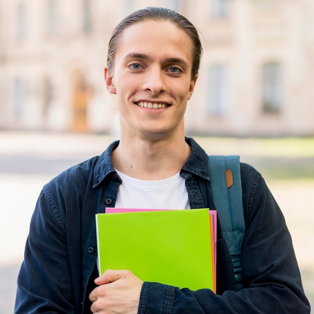 Bezpłatne zdjęcie portret przystojny studencki ono uśmiecha się