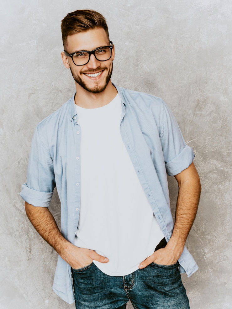 Bezpłatny plik Zdjęcie portret przystojny uśmiechnięty młodego człowieka model jest ubranym przypadkową koszula odziewa. moda stylowy mężczyzna pozowanie w okularach