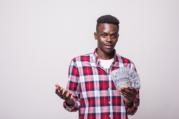 Portret radosny podekscytowany afro amerykański mężczyzna, trzymając banknoty pieniądze i patrząc na białym tle