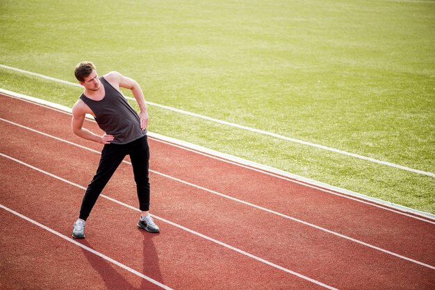 Portret robi ćwiczyć na biegowym śladzie sportowiec