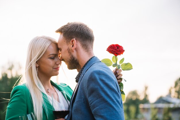 Portret romantyczna pary mienia czerwieni róża i wineglass