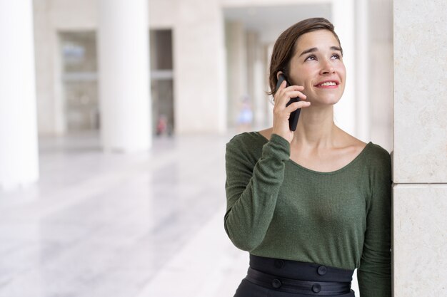 Portret rozochocony młody kierownik lub uczeń opowiada na telefonie