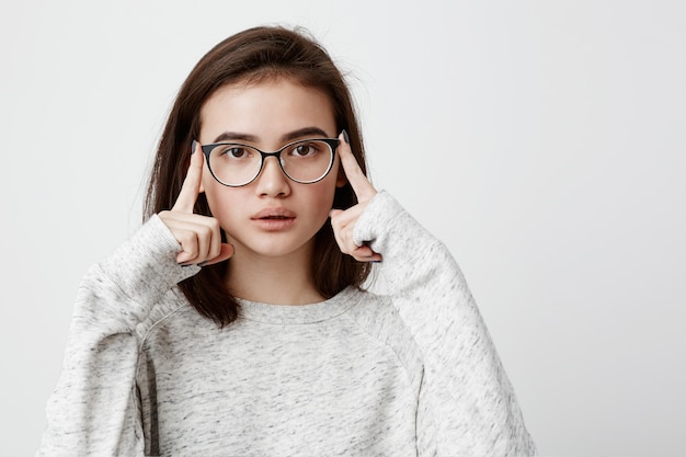 Portret Skoncentrowana Nastoletnia Kobieta Z Ciemnymi Prostymi Włosami Jest Ubranym Okulary W Zadumie Wyglądający