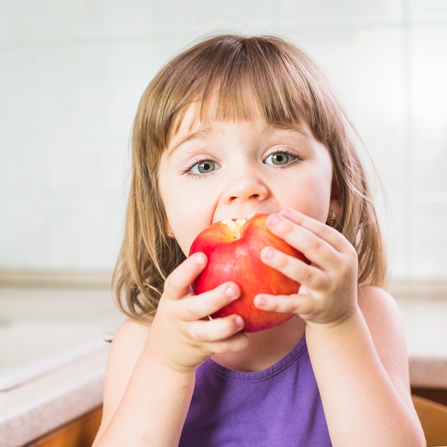 Portret śliczna dziewczyna je dojrzałego czerwonego jabłka