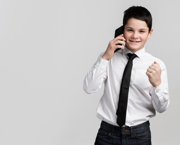 Portret śliczna młoda chłopiec opowiada na telefonie komórkowym