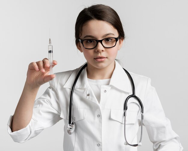 Portret śliczna młoda studenta medycyny mienia strzykawka