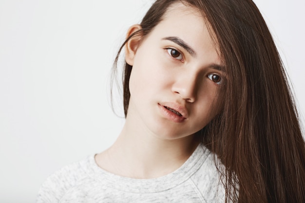 Portret śliczna nastoletnia kobieta z włosy z jednej strony patrzeje sfrustowany i zmęczony