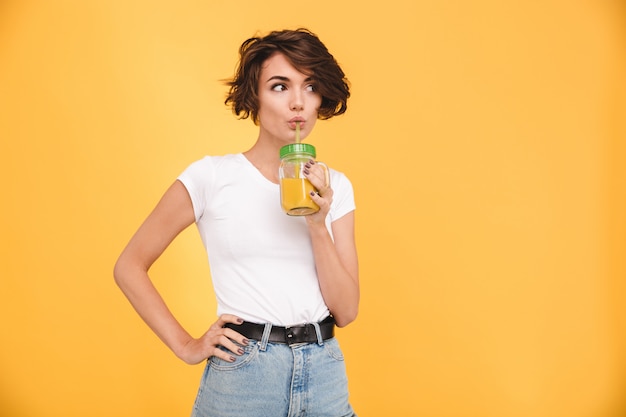 Portret śliczna przypadkowa kobieta pije sok pomarańczowego