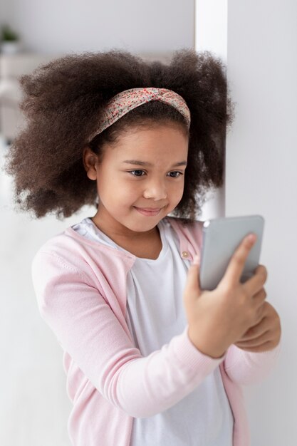 Portret śliczny młodej dziewczyny mienia telefon komórkowy