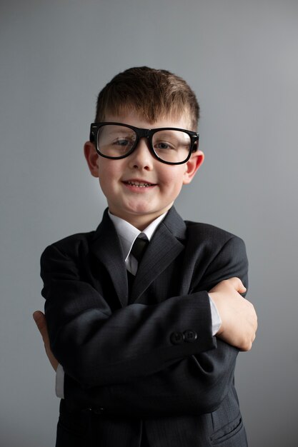 Portret słodkiego chłopca w garniturze i okularach
