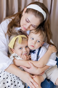 Portret spokojnej, zrównoważonej matki delikatnie przytula swoje dzieci szczęśliwe dzieci przytulają się nawzajem