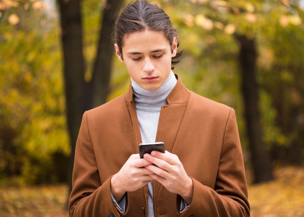 Bezpłatne zdjęcie portret sprawdza jego telefon młody człowiek