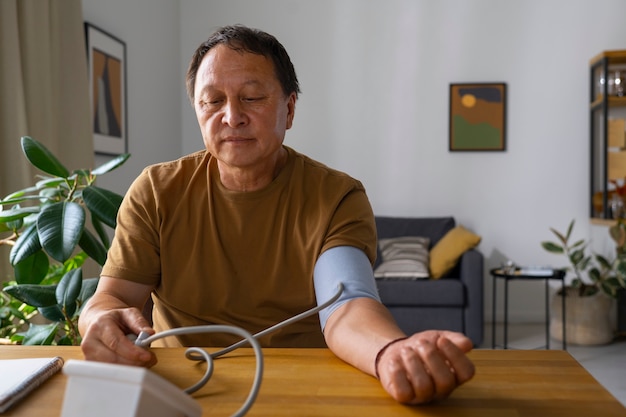 Bezpłatne zdjęcie portret starszego mężczyzny sprawdzającego ciśnienie krwi w domu