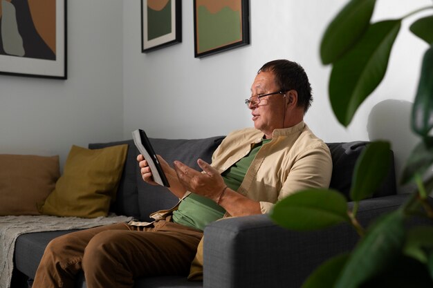 Portret starszego mężczyzny za pomocą tabletu w domu