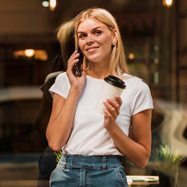 Portret stylowej młodej kobiety rozmawia przez telefon