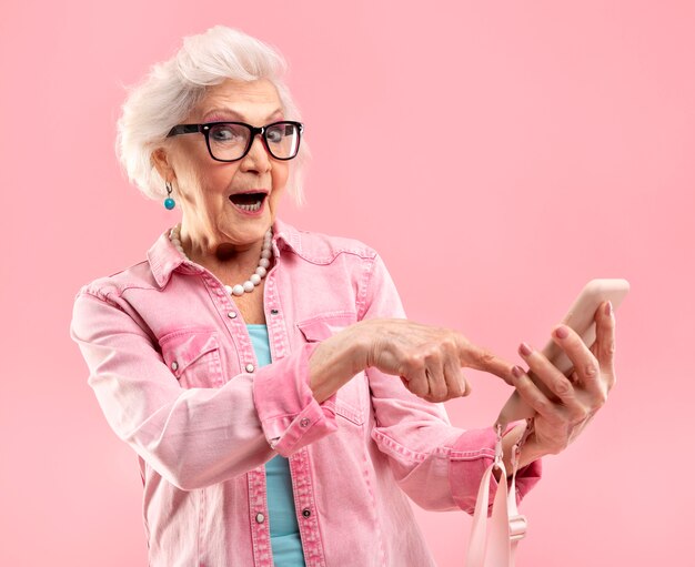 Portret stylowej starszej kobiety w kolorze różowym